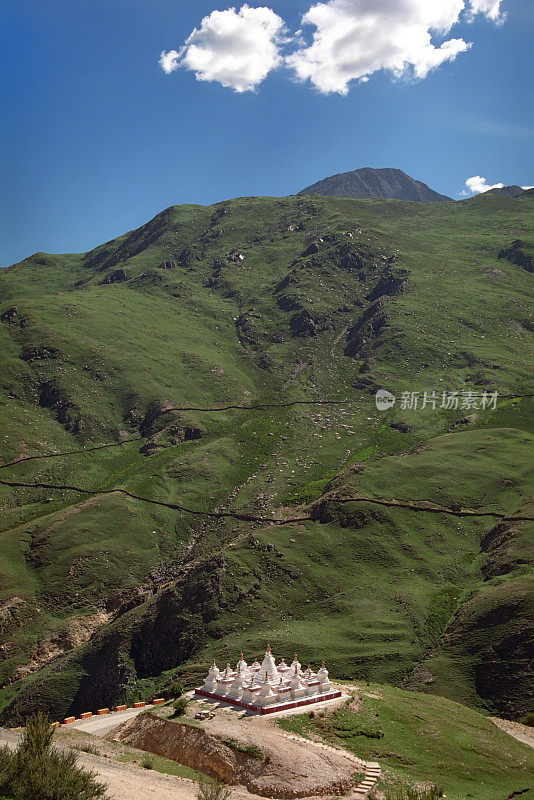 绿色的山和白色的佛塔附近的佛洞寺Druk Yerpa。